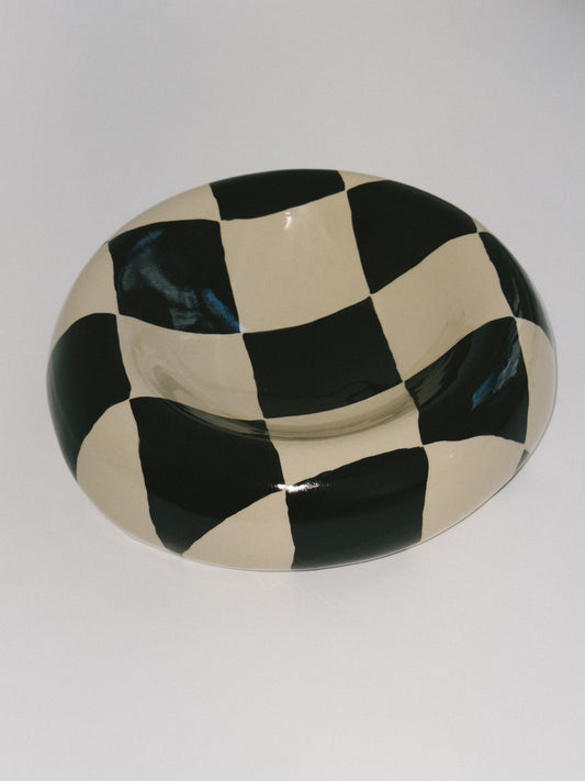Handgeformter Keramikteller von Zoe Deno. Gefertigt in Wien. Material: Ton, glasiert. Bemalt in Schwarz und Beige im Schachbrettmuster. Jedes Stück ist ein Unikat. Als Wandobjekt oder Tellerskulptur nutzbar.
